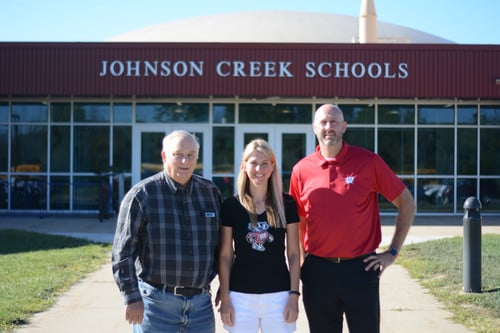 Dale, Jenny, and Neil in front of the school