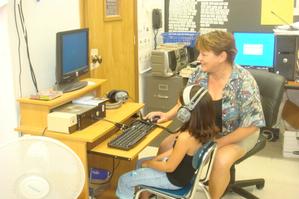 Teacher with child working on computer